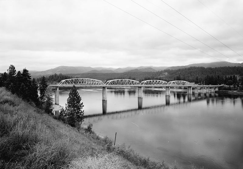 Black-and-white photo of the steel-arch Oldtown Bridge crossing the Pend Oreille River